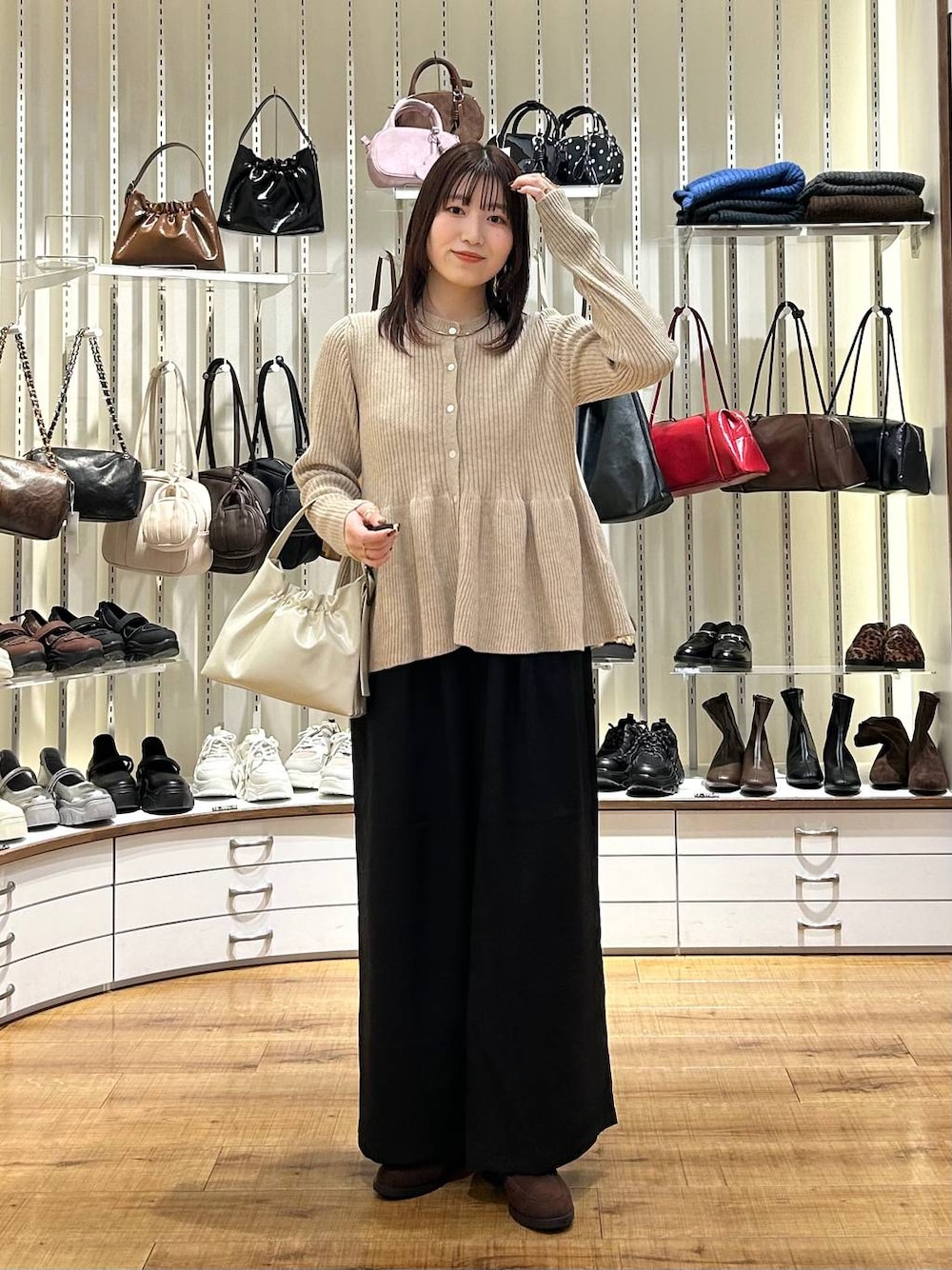 ブラック系のその他パンツ、ブラウン系のローファー、ベージュ系のカーディガン/ボレロを着用したレディースの秋コーディネートの1枚目の写真