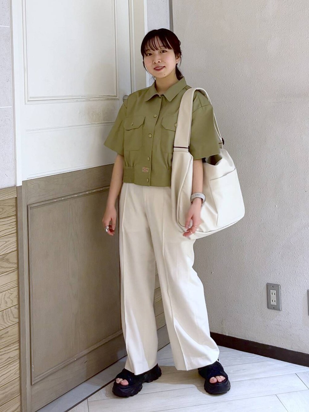 ブラック系のサンダル、ホワイト系のボディバッグ/ウエストポーチ、ホワイト系のスラックスを着用したレディースの春コーディネートの1枚目の写真