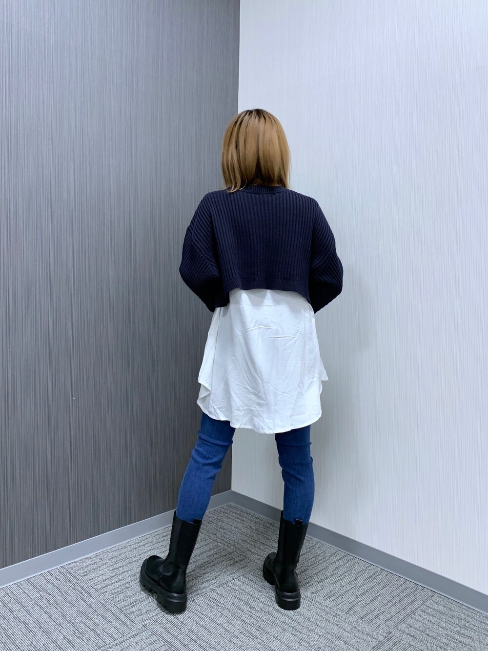 ブラック系のニット/セーター、ブルー系のデニムパンツ、ホワイト系のショルダーバッグを着用したレディースの冬コーディネートの3枚目の写真