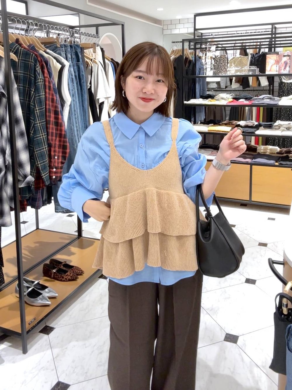 ブラウン系のその他パンツ、ブラック系のショルダーバッグ、ブルー系のシャツ/ブラウスを着用したレディースの秋コーディネートの1枚目の写真