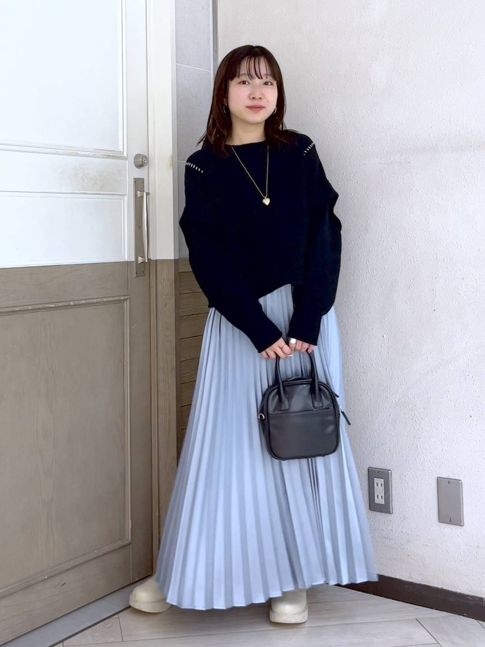 ブラック系のTシャツ/カットソー、ホワイト系のブーツ、ブラック系のボストンバッグを着用したレディースの冬コーディネートの1枚目の写真