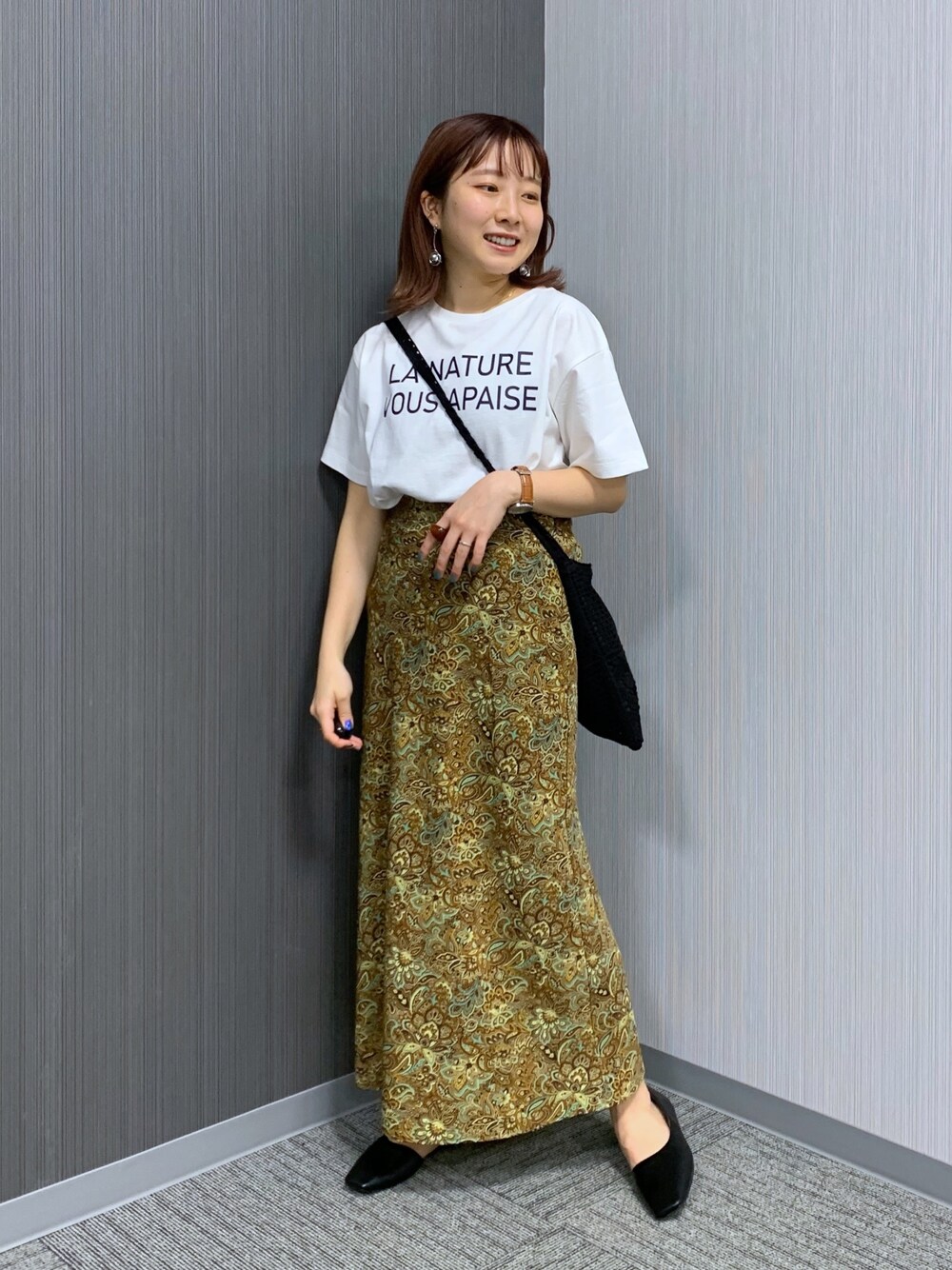 ホワイト系のTシャツ/カットソー、ブラウン系のスカート、ブラック系のショルダーバッグを着用したレディースの春コーディネートの2枚目の写真
