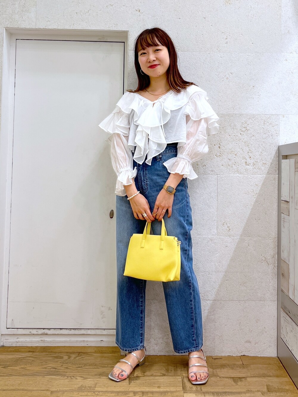 ホワイト系のシャツ/ブラウス、ブルー系のパンツ、イエロー系のバッグを着用したレディースの夏コーディネートの1枚目の写真