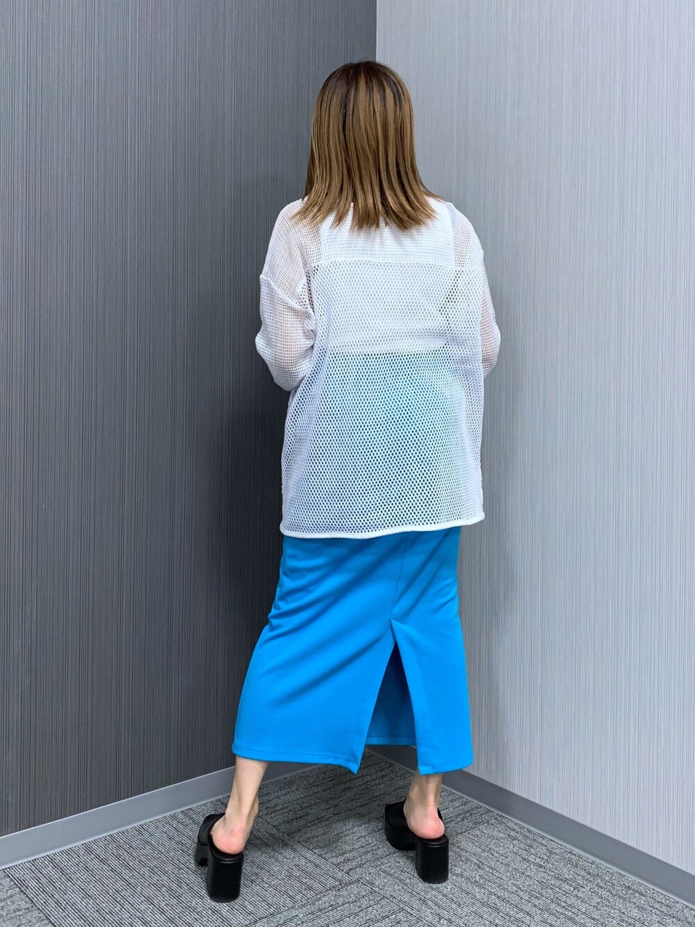 ホワイト系のTシャツ/カットソー、ブルー系のスカート、ブラック系のショルダーバッグを着用したレディースの春コーディネートの3枚目の写真