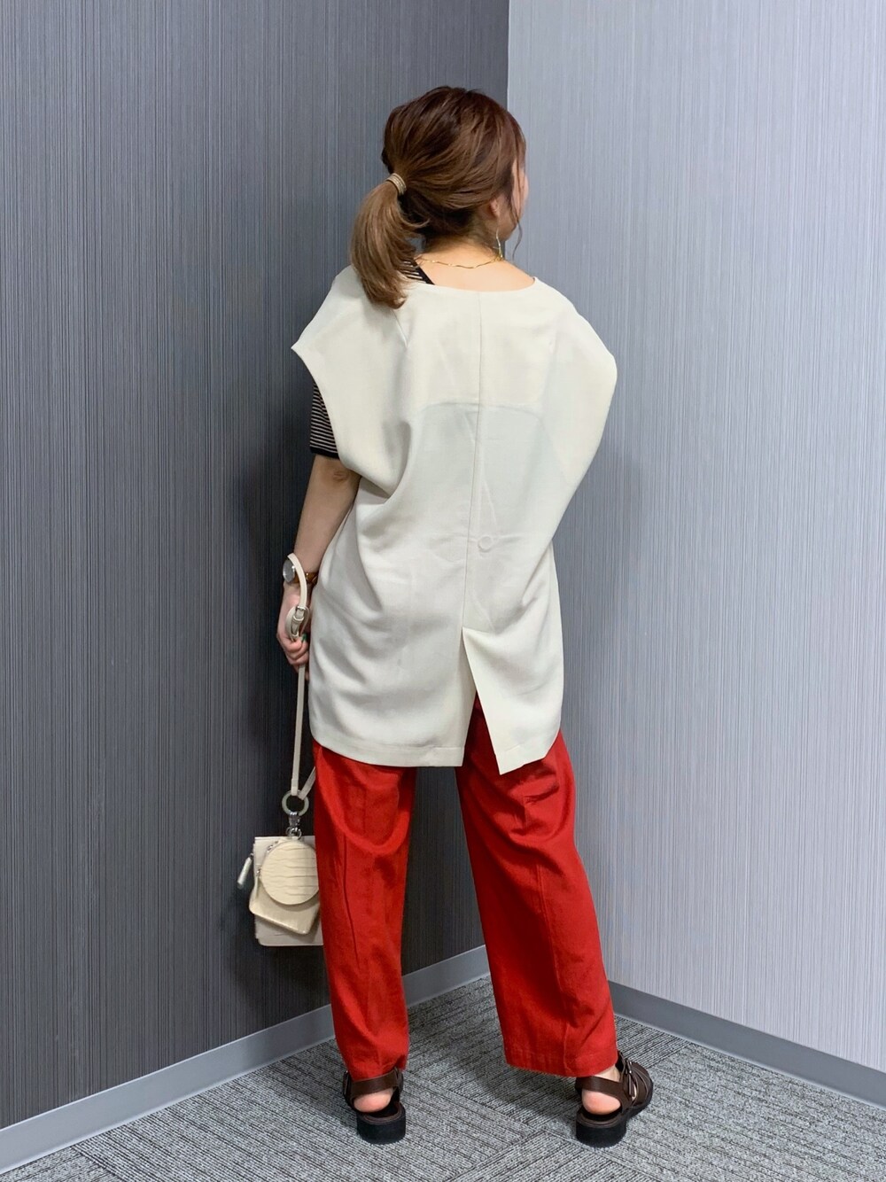 ブラック系のTシャツ/カットソー、レッド系のその他パンツ、ホワイト系のショルダーバッグを着用したレディースの夏コーディネートの3枚目の写真