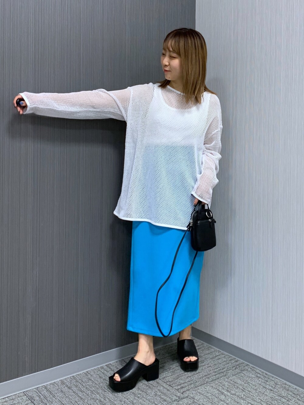 ホワイト系のTシャツ/カットソー、ブルー系のスカート、ブラック系のショルダーバッグを着用したレディースの春コーディネートの2枚目の写真