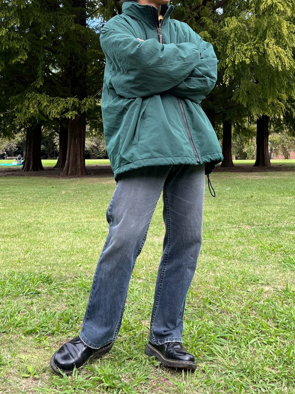 ブラック系のデニムパンツ、グリーン系のマウンテンパーカー、ブラック系のブーツを着用したメンズの冬コーディネートの1枚目の写真