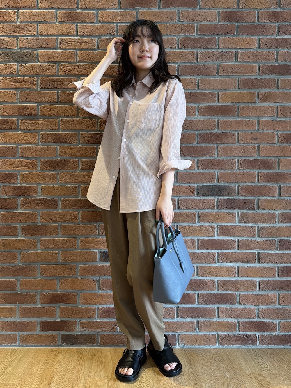 ピンク系のシャツ/ブラウス、ブラウン系のスラックス、ブルー系のトートバッグを着用したメンズの夏コーディネートの1枚目の写真