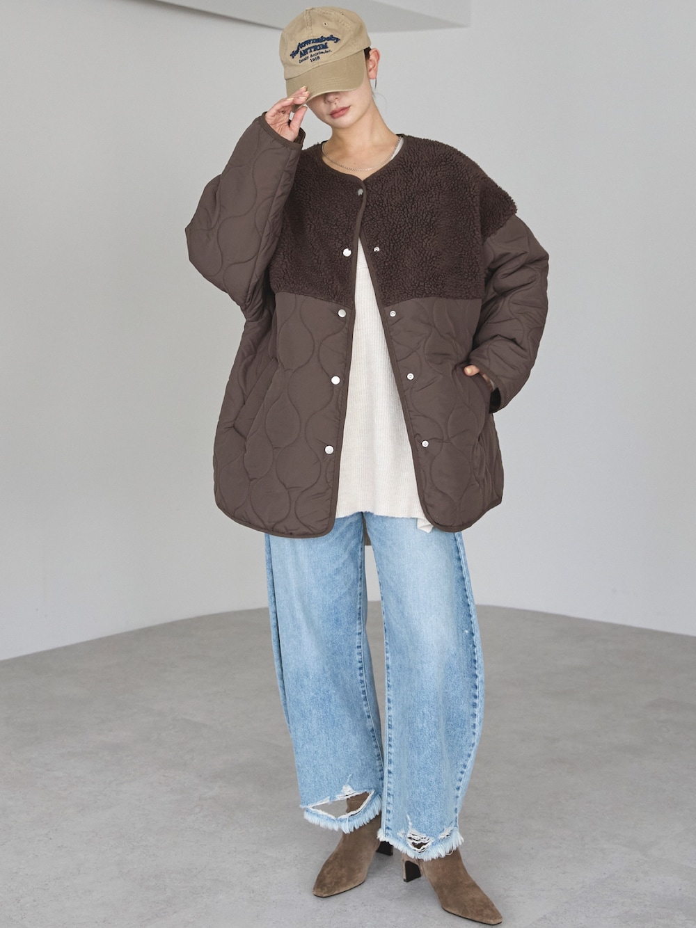 ブラウン系のノーカラージャケットを着用したレディースの冬コーディネートの1枚目の写真