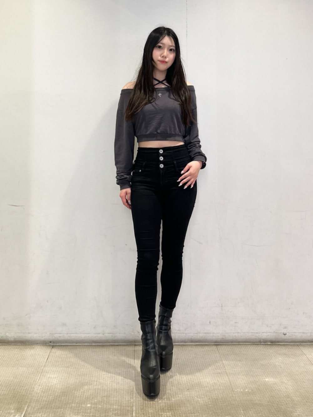 ブラック系のデニムパンツ、グレー系のスウェット、ブラック系のブーツを着用したレディースの秋コーディネートの1枚目の写真
