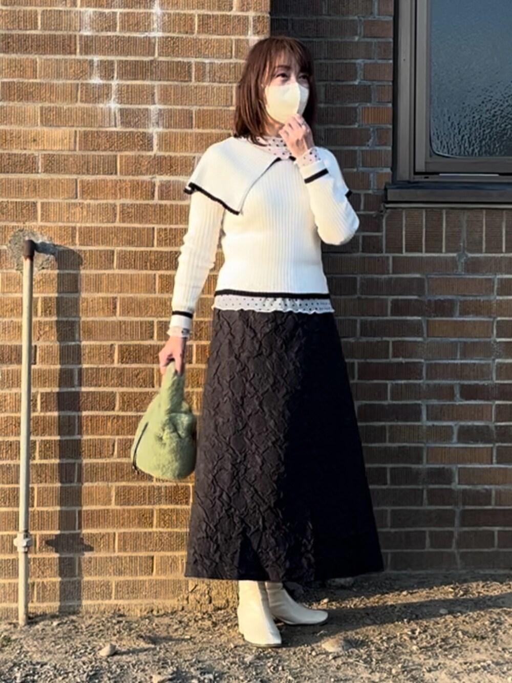 ホワイト系のブーツ、ホワイト系のニット/セーター、ホワイト系のシャツ/ブラウスを着用したレディースの冬コーディネートの1枚目の写真