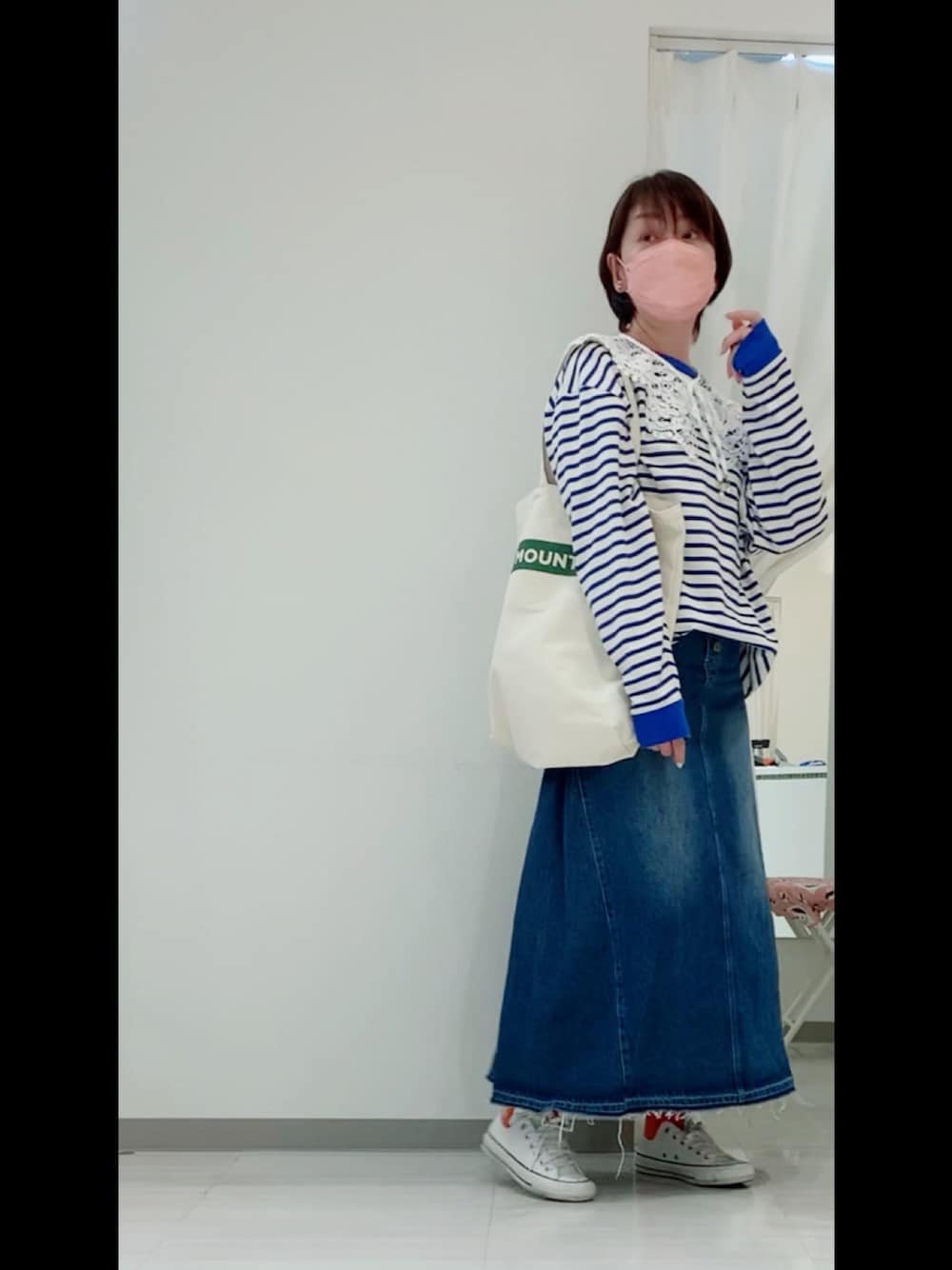 ブルー系のTシャツ/カットソー、ブルー系のデニムスカート、ホワイト系のスニーカーを着用したレディースの春コーディネートの1枚目の写真