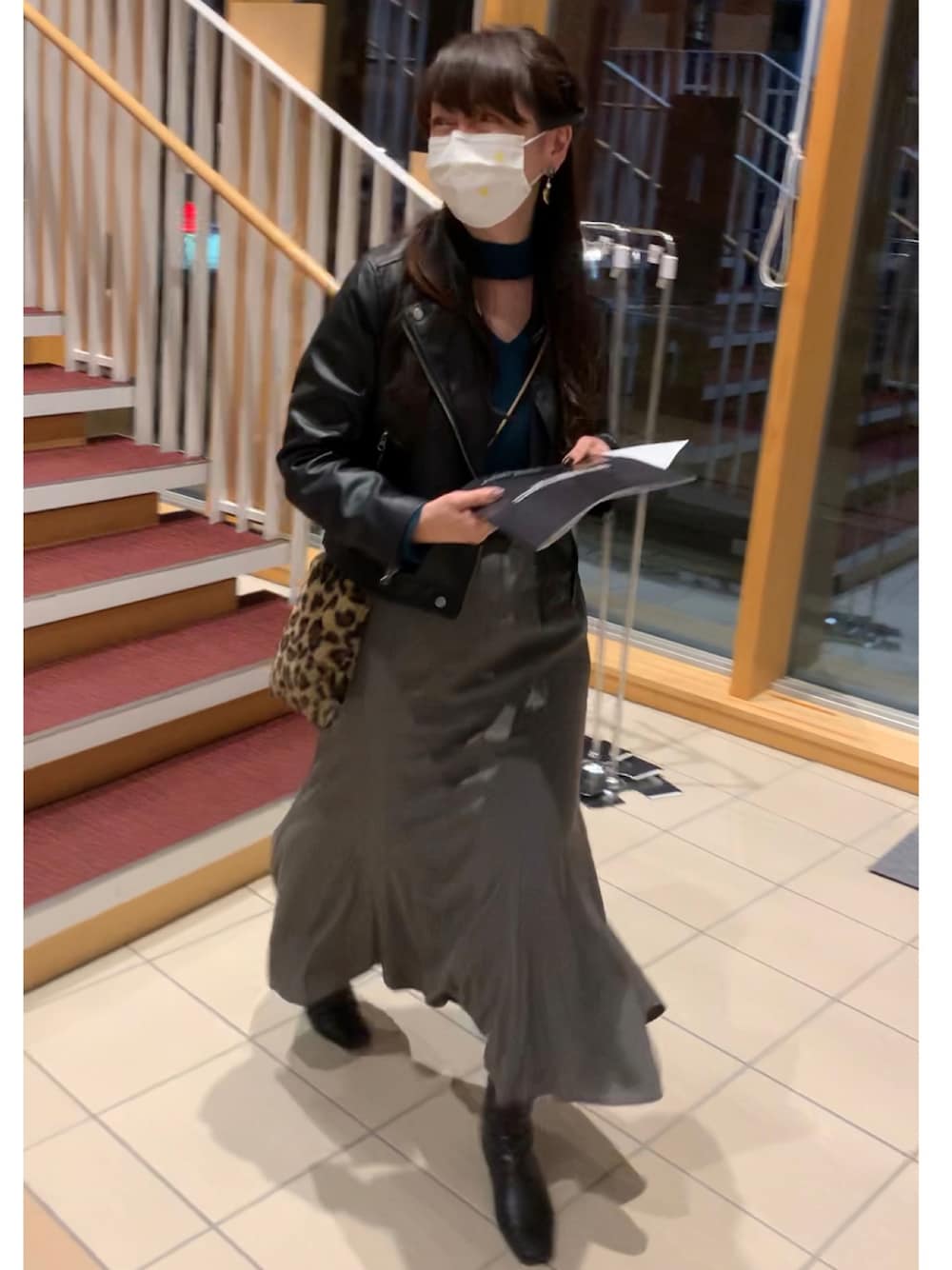 ブラック系のライダースジャケット、グレー系のスカート、ブラウン系のバッグを着用したレディースの秋コーディネートの1枚目の写真