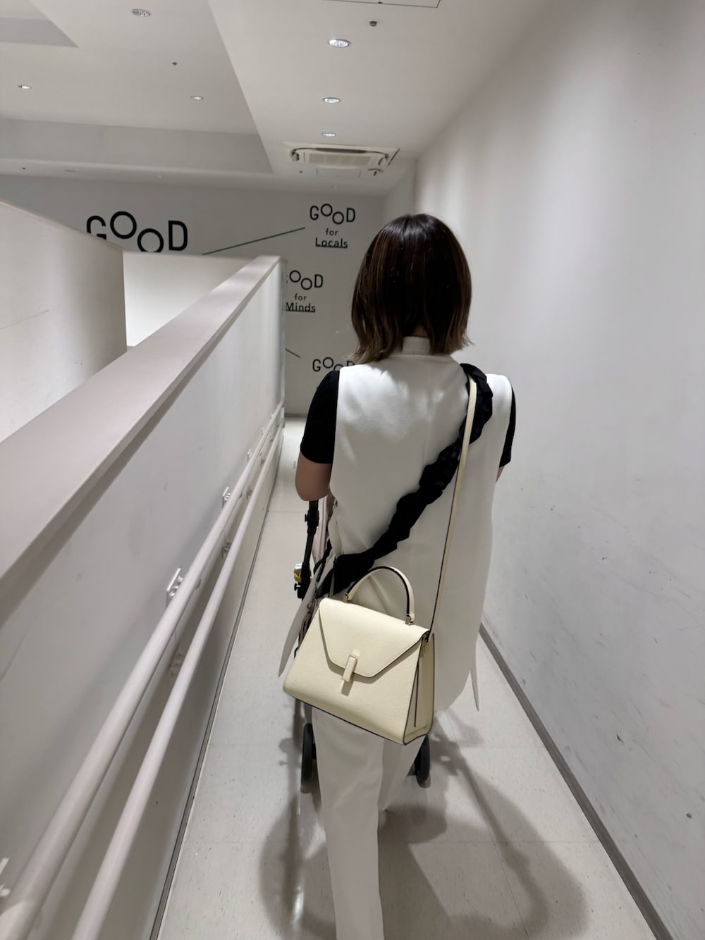 ホワイト系のその他アウター、ホワイト系のハンドバッグ、ホワイト系のスラックスを着用したレディースの秋コーディネートの1枚目の写真