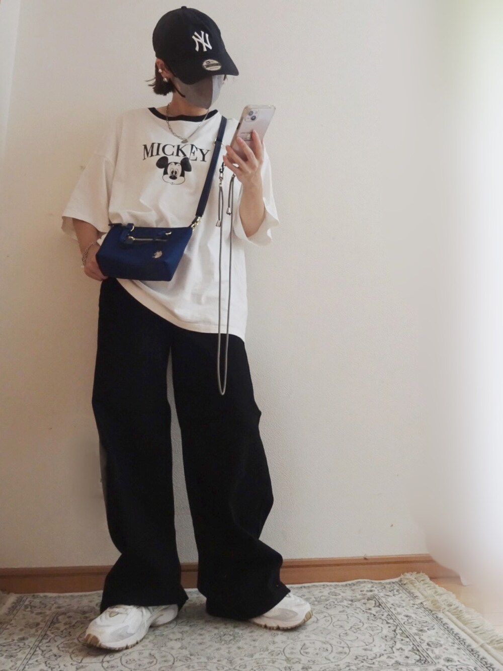 ブラック系のデニムパンツ、ブルー系のショルダーバッグ、ホワイト系のTシャツ/カットソーを着用したレディースの秋コーディネートの1枚目の写真