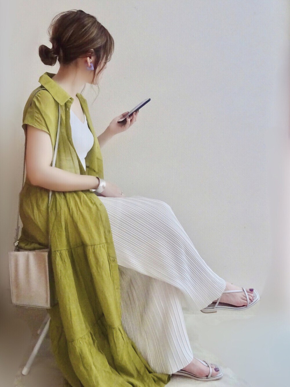 グリーン系のワンピース、ホワイト系のその他パンツ、シルバー系のショルダーバッグを着用したレディースの夏コーディネートの1枚目の写真