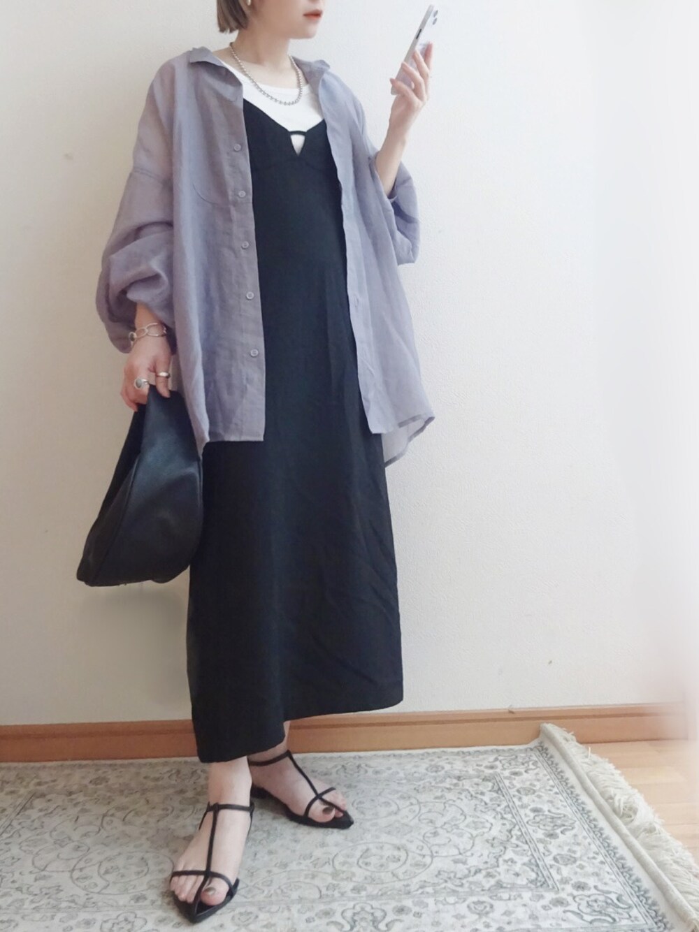 ブラック系のジャンパースカート、パープル系のシャツ/ブラウス、ブラック系のショルダーバッグを着用したレディースの春コーディネートの1枚目の写真