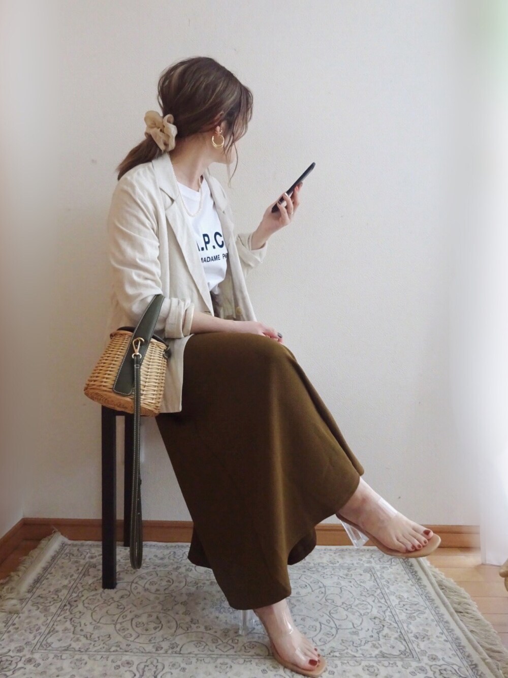 ベージュ系のジャケット/アウター、ブラウン系のスカート、ベージュ系のサンダルを着用したレディースの春コーディネートの1枚目の写真