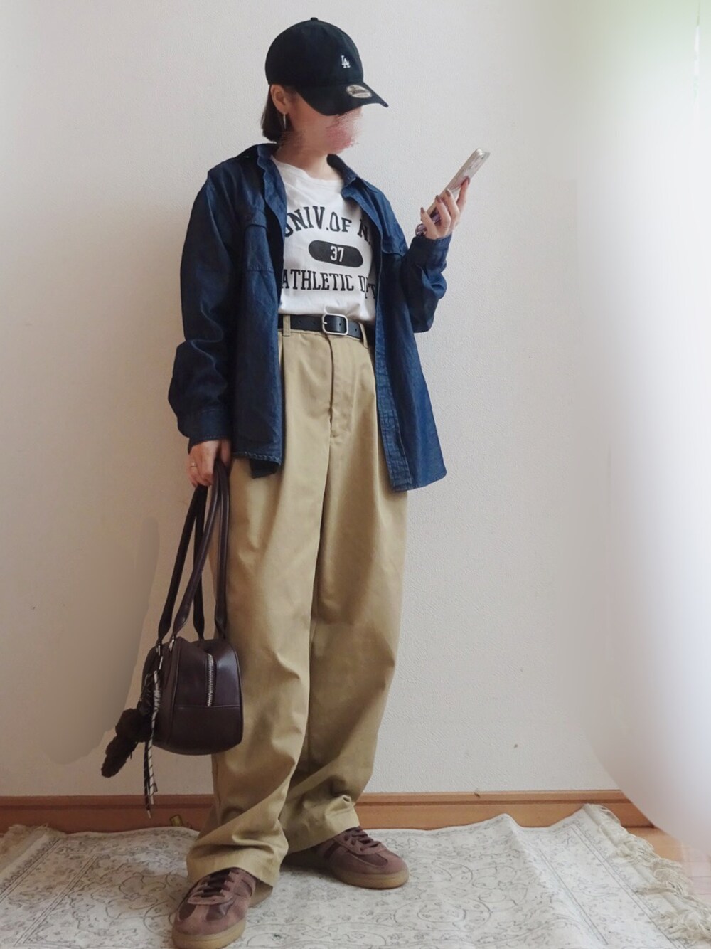 ホワイト系のTシャツ/カットソー、ベージュ系のチノパンツ、ブラウン系のスニーカーを着用したレディースの秋コーディネートの1枚目の写真