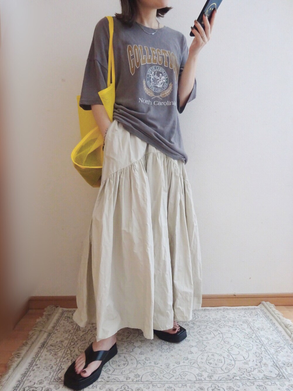 グレー系のTシャツ/カットソー、ホワイト系のスカート、ブラック系のサンダルを着用したレディースの夏コーディネートの1枚目の写真