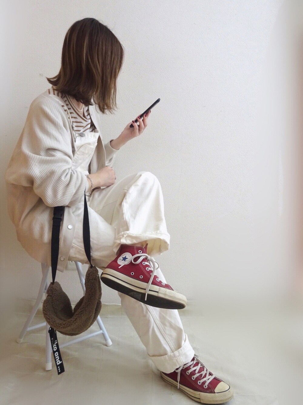 ベージュ系のカーディガン/ボレロ、レッド系のスニーカー、ブラウン系のTシャツ/カットソーを着用したレディースの秋コーディネートの1枚目の写真