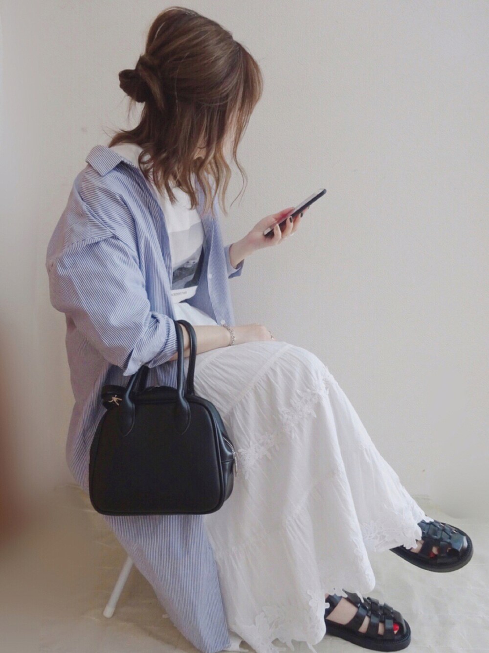 ブラック系のトートバッグ、ホワイト系のTシャツ/カットソー、ブルー系のシャツワンピースを着用したレディースの夏コーディネートの1枚目の写真