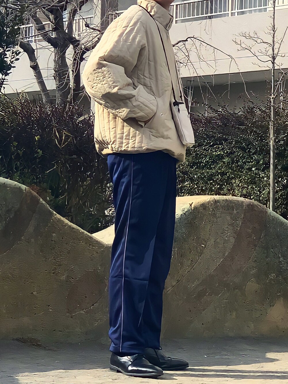 ブラック系のドレスシューズ、ブルー系のパンツ、ベージュ系のブルゾンを着用したメンズの冬コーディネートの1枚目の写真