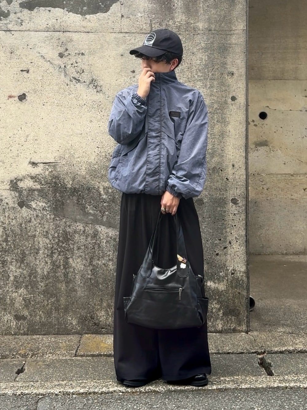 ブラック系のショルダーバッグ、ブラック系のスラックス、ベージュ系のブルゾンを着用したメンズの秋コーディネートの1枚目の写真