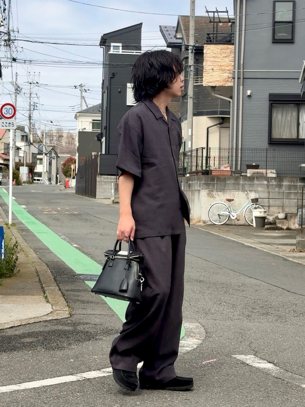 グレー系のシャツ/ブラウス、グレー系のスラックス、ブラック系のスニーカーを着用したメンズの春コーディネートの1枚目の写真
