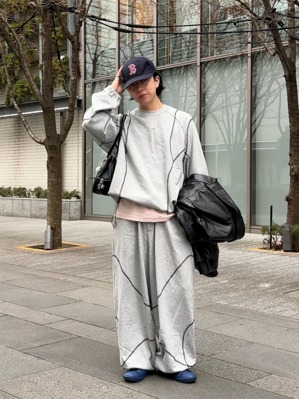 グレー系のスウェットパンツ、グレー系のスウェット、ブラック系のショルダーバッグを着用したメンズの冬コーディネートの1枚目の写真