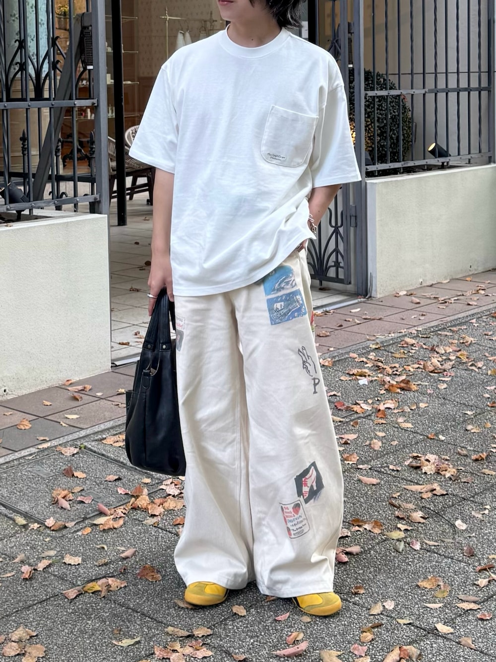 ホワイト系のその他パンツ、ブラック系のショルダーバッグ、イエロー系のスニーカーを着用したメンズの春コーディネートの1枚目の写真