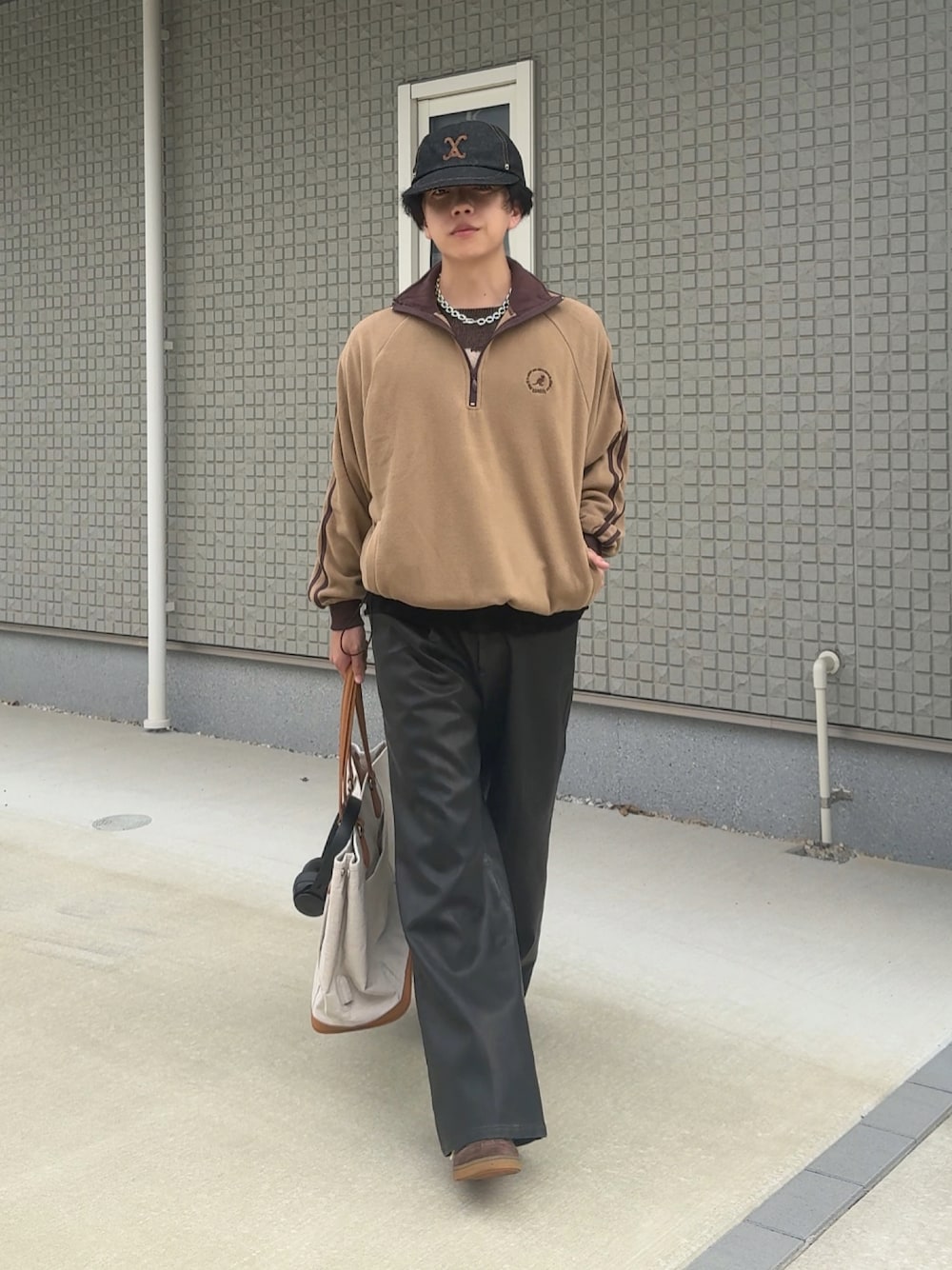 ブラック系のその他パンツ、ベージュ系のボストンバッグ、ブラウン系のスニーカーを着用したメンズの秋コーディネートの1枚目の写真
