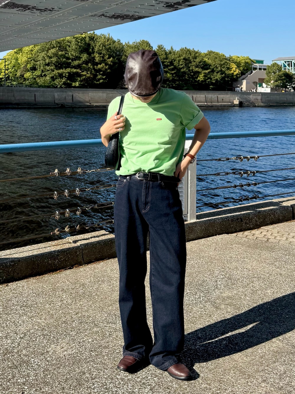 ブルー系のデニムパンツ、グリーン系のTシャツ/カットソー、ブラウン系のアナログ腕時計を着用したメンズの春コーディネートの1枚目の写真