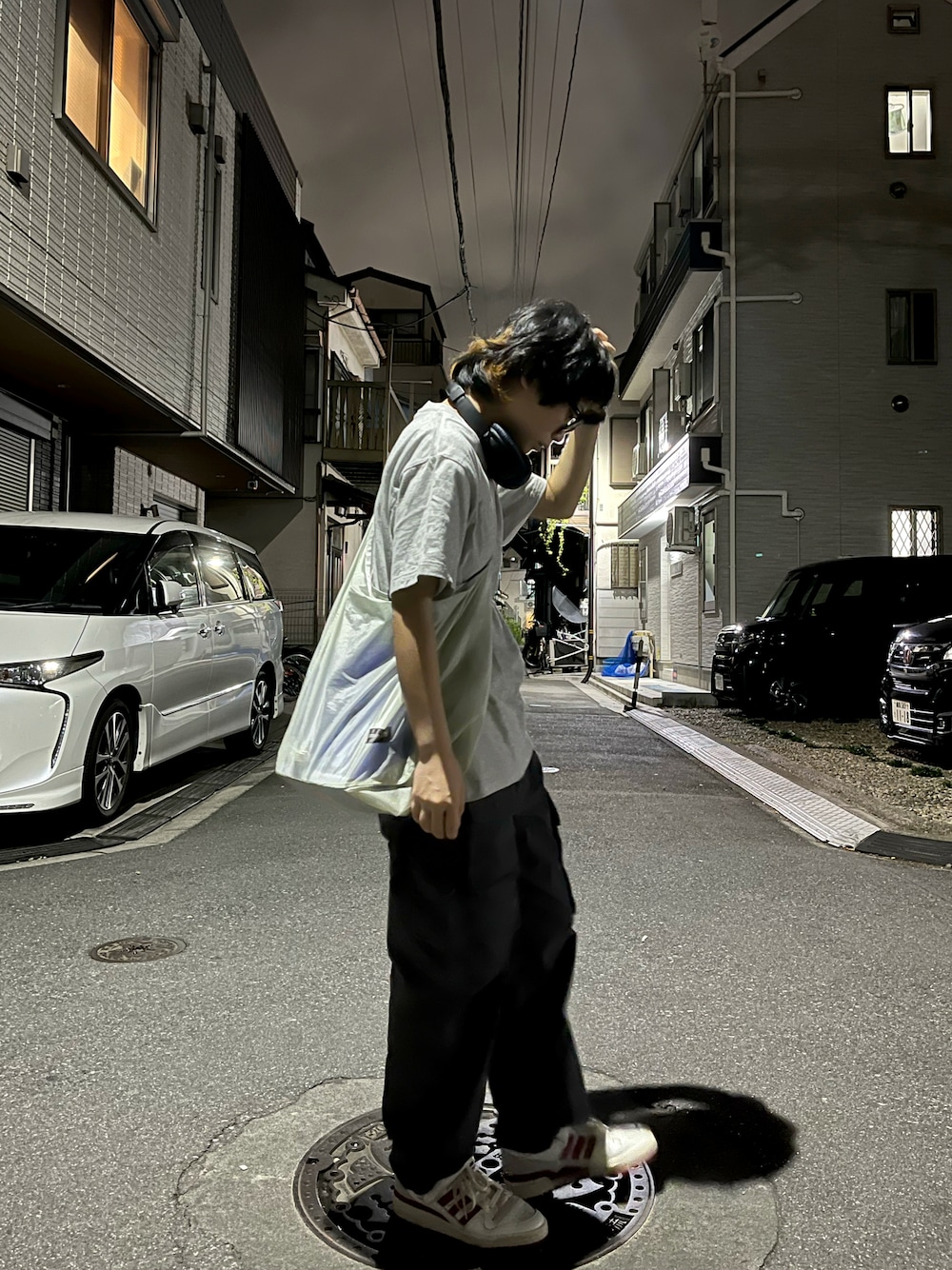 グレー系のカーゴパンツ、ホワイト系のバッグ、レッド系のスニーカーを着用したレディースの夏コーディネートの1枚目の写真