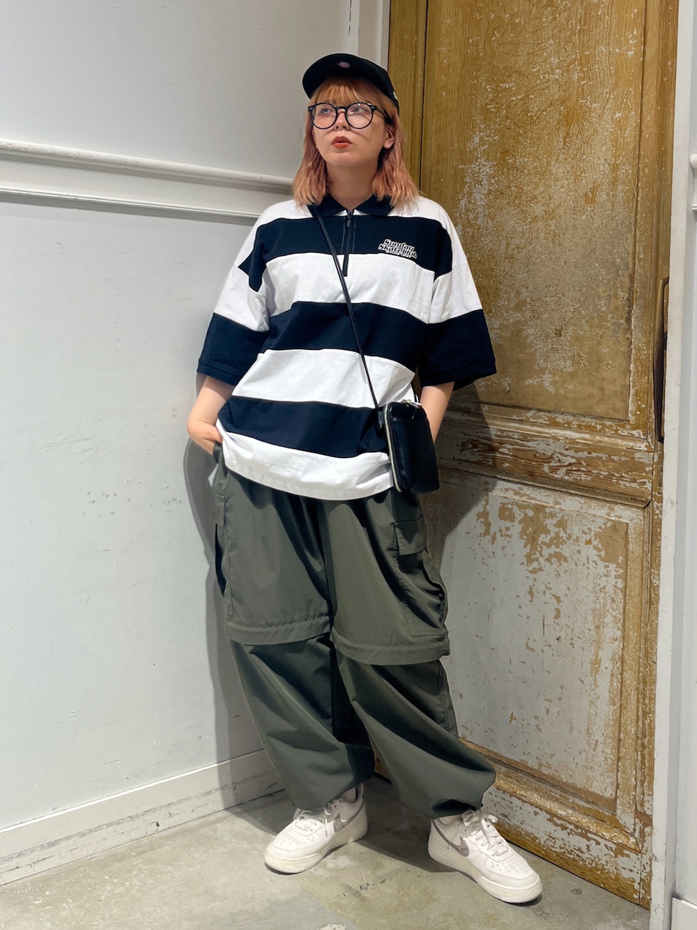 ブラック系のショルダーバッグ、ホワイト系のTシャツ/カットソー、グリーン系のカーゴパンツを着用したレディースの夏コーディネートの1枚目の写真