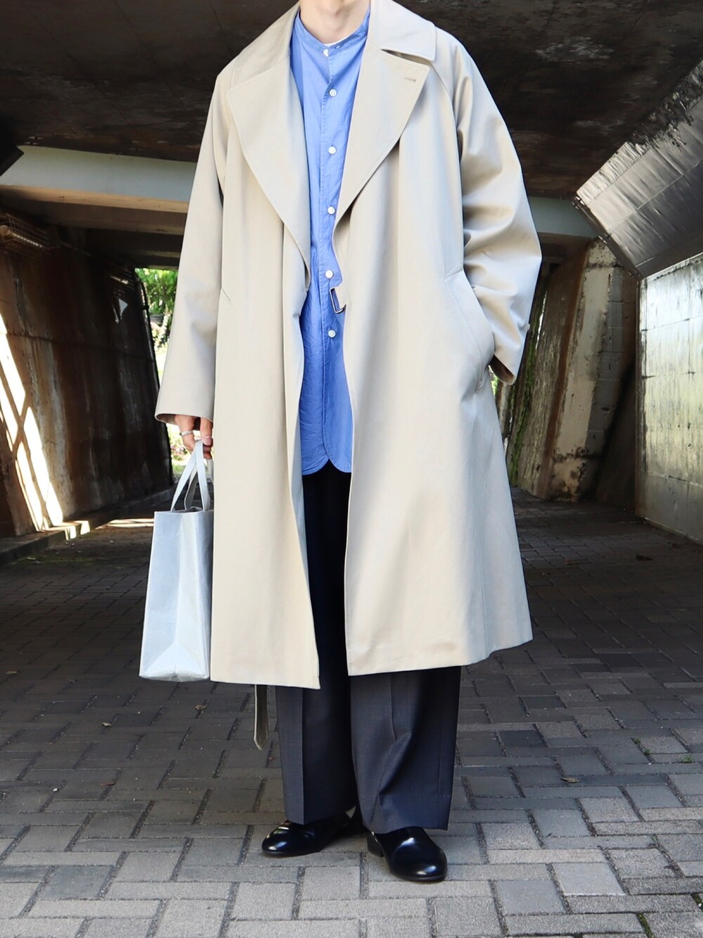 「コート、スラックス、革靴、きれいめカジュアル、シャツスタイル、秋服、シンプルスタイル、グレーパンツ、青シャツ、COMOLI、ベージュコート、バンドカラーシャツ、タイロッケンコート、スポックシューズ、だから秋服が好き」｜「COMOLIのアイテム（ジャケット/アウター、ベージュ系）」を使った、takakiさん（メンズ・165cm）の秋コーディネートの1枚目の写真