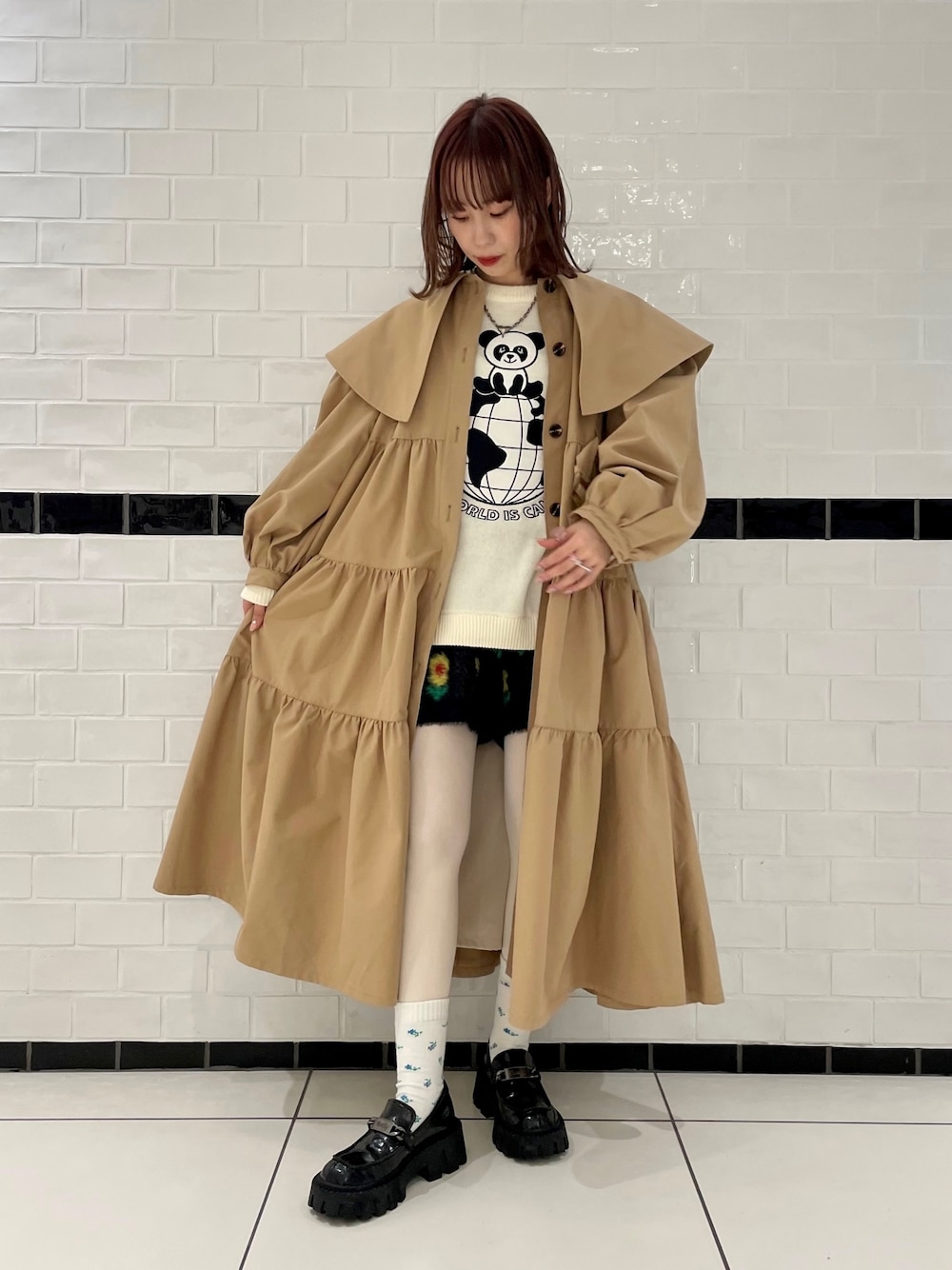 ベージュ系のトレンチコート、ホワイト系のニット/セーター、ブラック系のその他パンツを着用したレディースの冬コーディネートの1枚目の写真