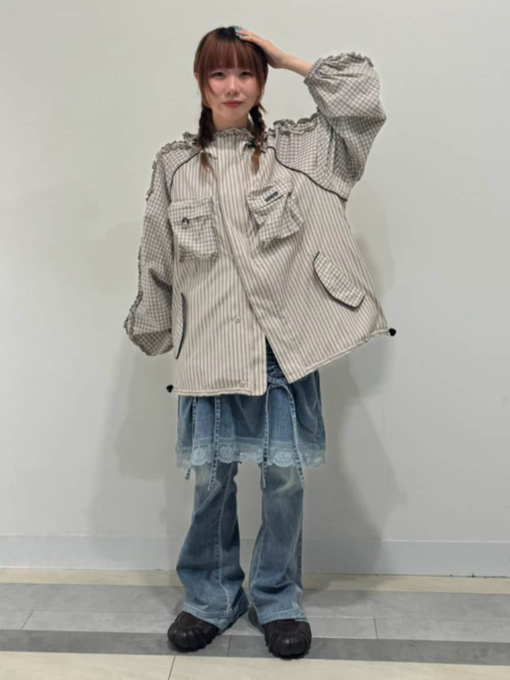 ベージュ系のブルゾン、ブルー系のデニムパンツを着用したレディースの秋コーディネートの1枚目の写真