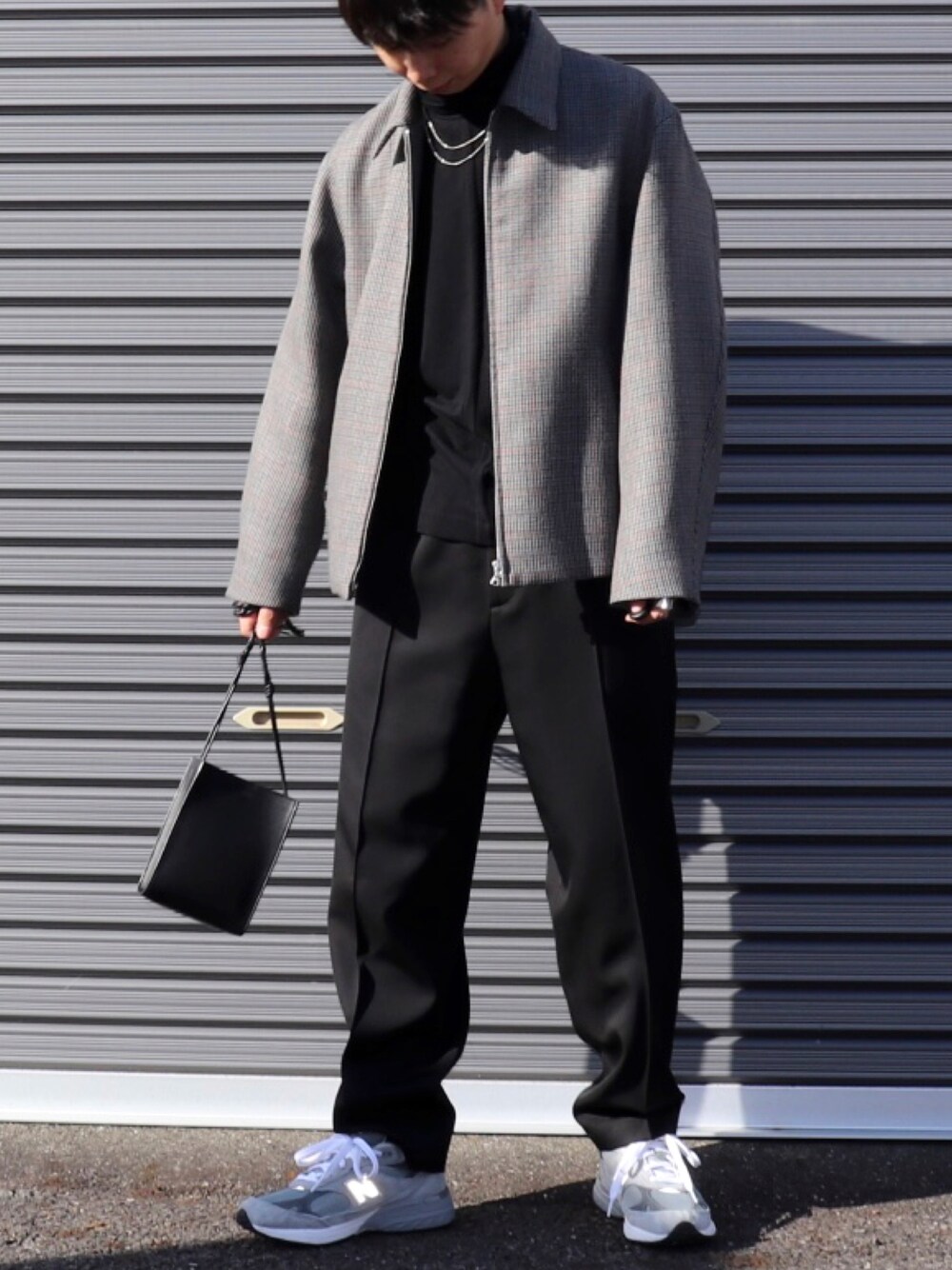 グレー系のブルゾン、ブラック系のニット/セーター、ブラック系のパンツを着用したメンズの春コーディネートの1枚目の写真