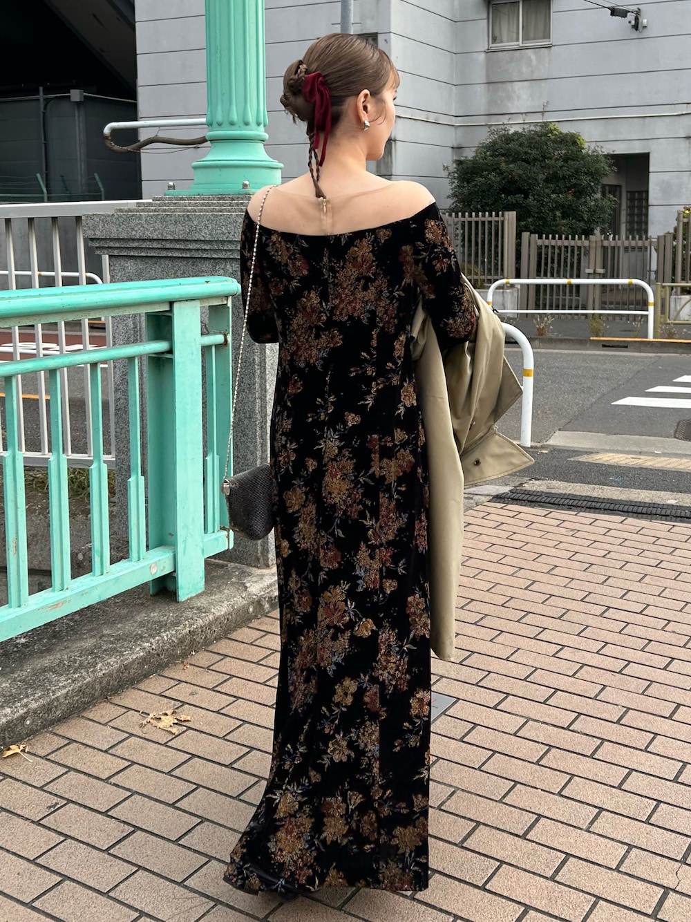 ブラック系のパンプス、ブラック系のドレス、ベージュ系のトレンチコートを着用したレディースの秋コーディネートの1枚目の写真