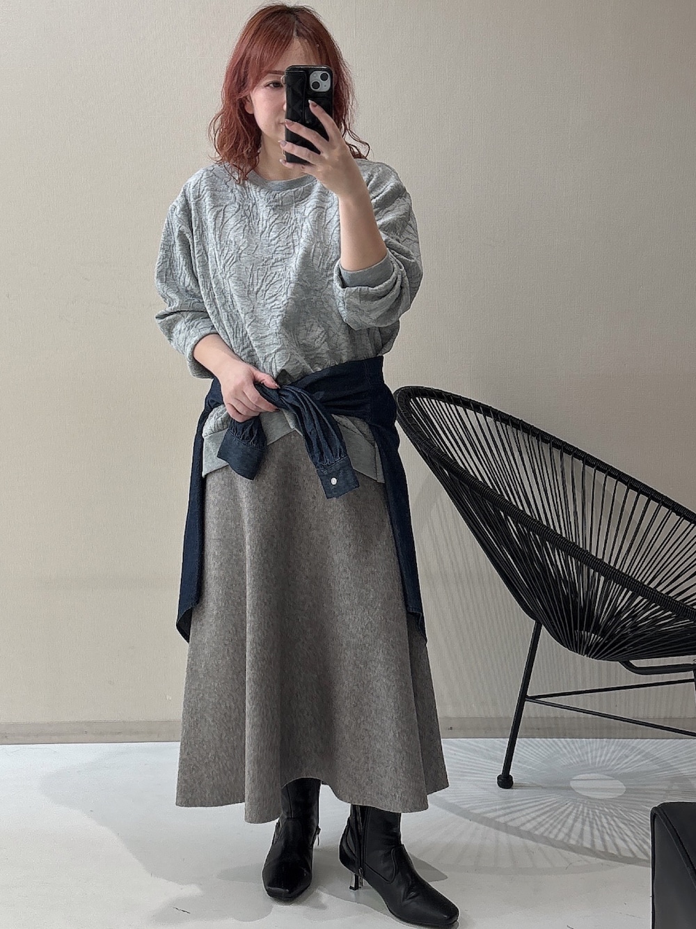 ブラック系のブーツ、グレー系のTシャツ/カットソー、グレー系のスカートを着用したレディースの冬コーディネートの1枚目の写真