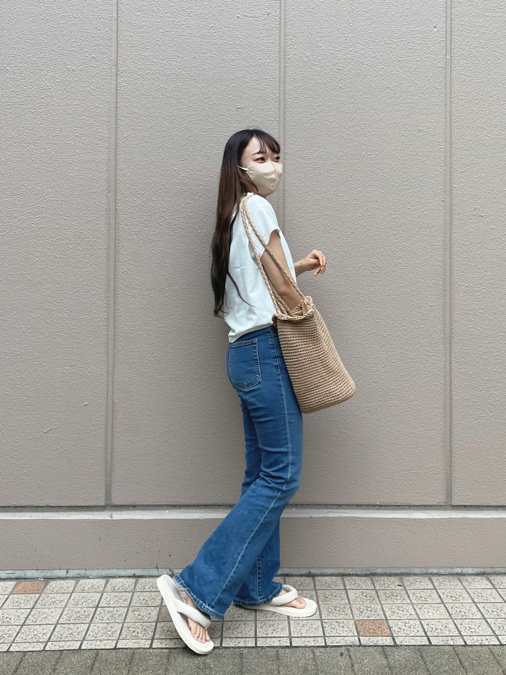 ホワイト系のTシャツ/カットソー、ブルー系のデニムパンツ、ベージュ系のトートバッグを着用したレディースの夏コーディネートの1枚目の写真