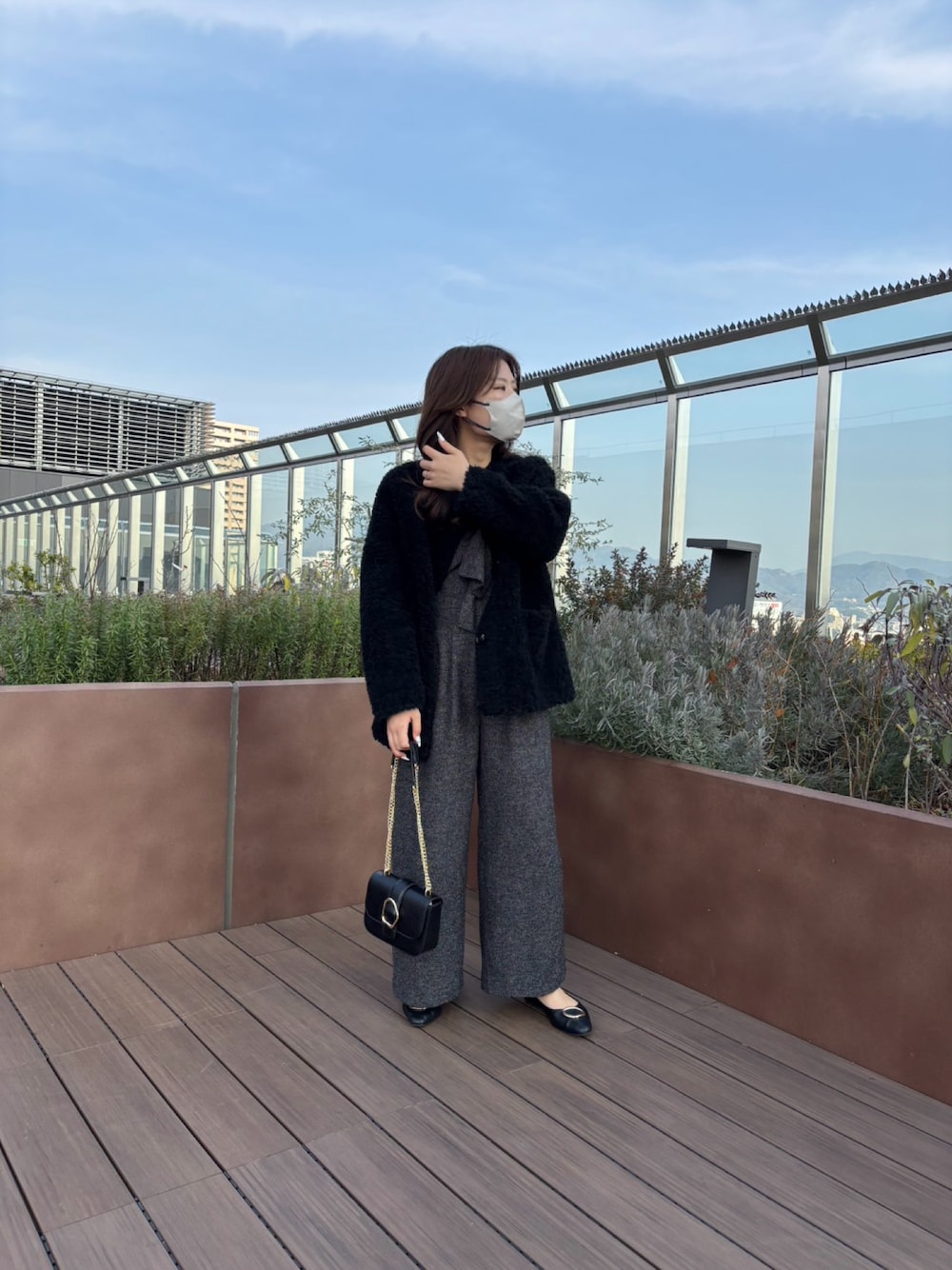 ブラック系のノーカラージャケット、ブラック系のサロペット/オーバーオール、ブラック系のショルダーバッグを着用したレディースの冬コーディネートの1枚目の写真