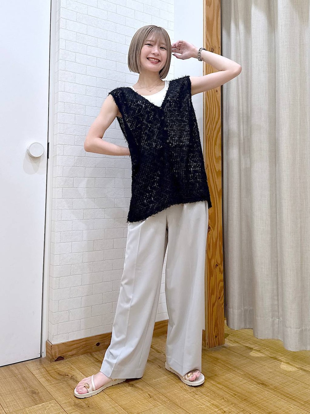 グレー系のその他パンツ、ホワイト系のタンクトップ、ベージュ系のサンダルを着用したレディースの夏コーディネートの1枚目の写真