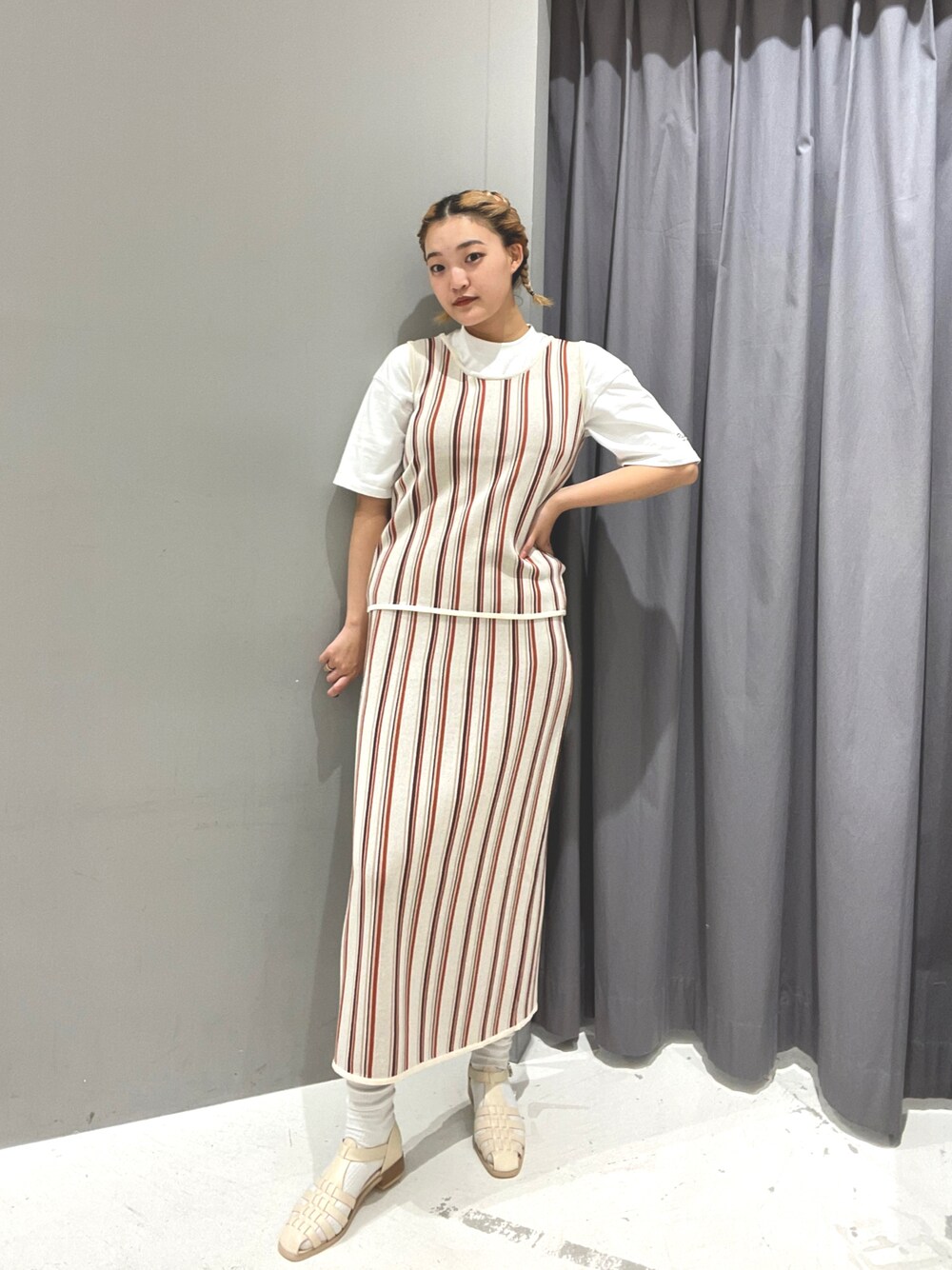 ホワイト系のスカート、ホワイト系のTシャツ/カットソー、ホワイト系のベストを着用したレディースの春コーディネートの1枚目の写真