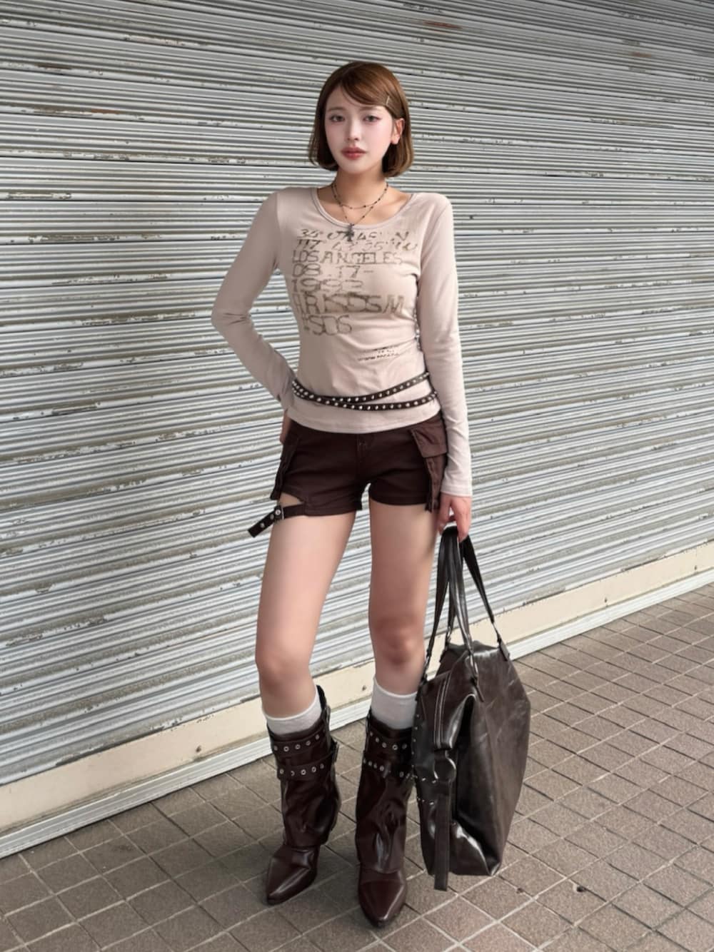 ベージュ系のTシャツ/カットソー、ブラウン系のデニムパンツ、ブラウン系のブーツを着用したレディースの秋コーディネートの1枚目の写真
