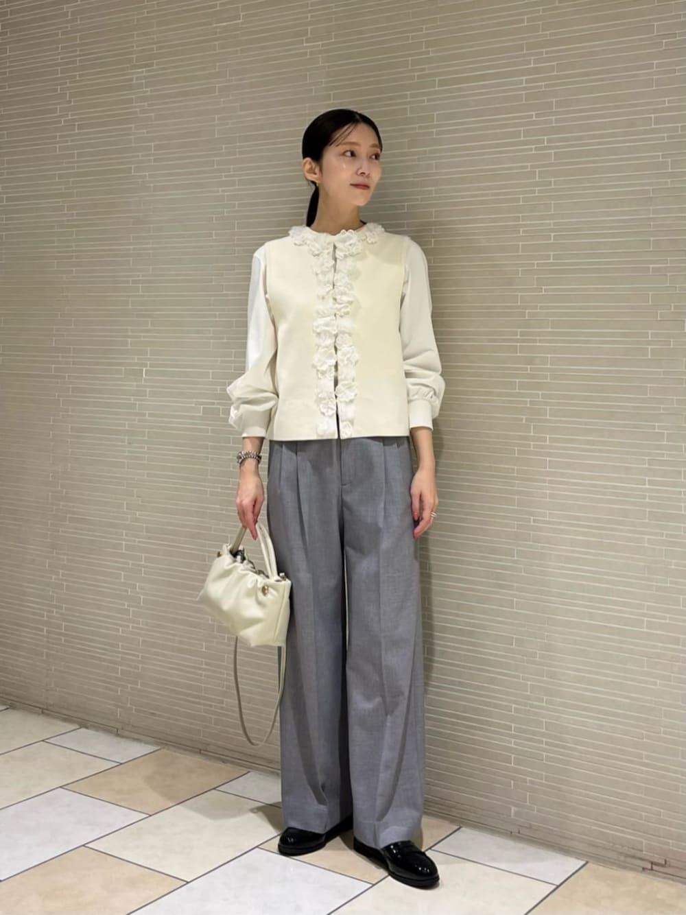 ホワイト系のTシャツ/カットソー、ホワイト系のベスト、グレー系のその他パンツを着用したレディースの冬コーディネートの1枚目の写真