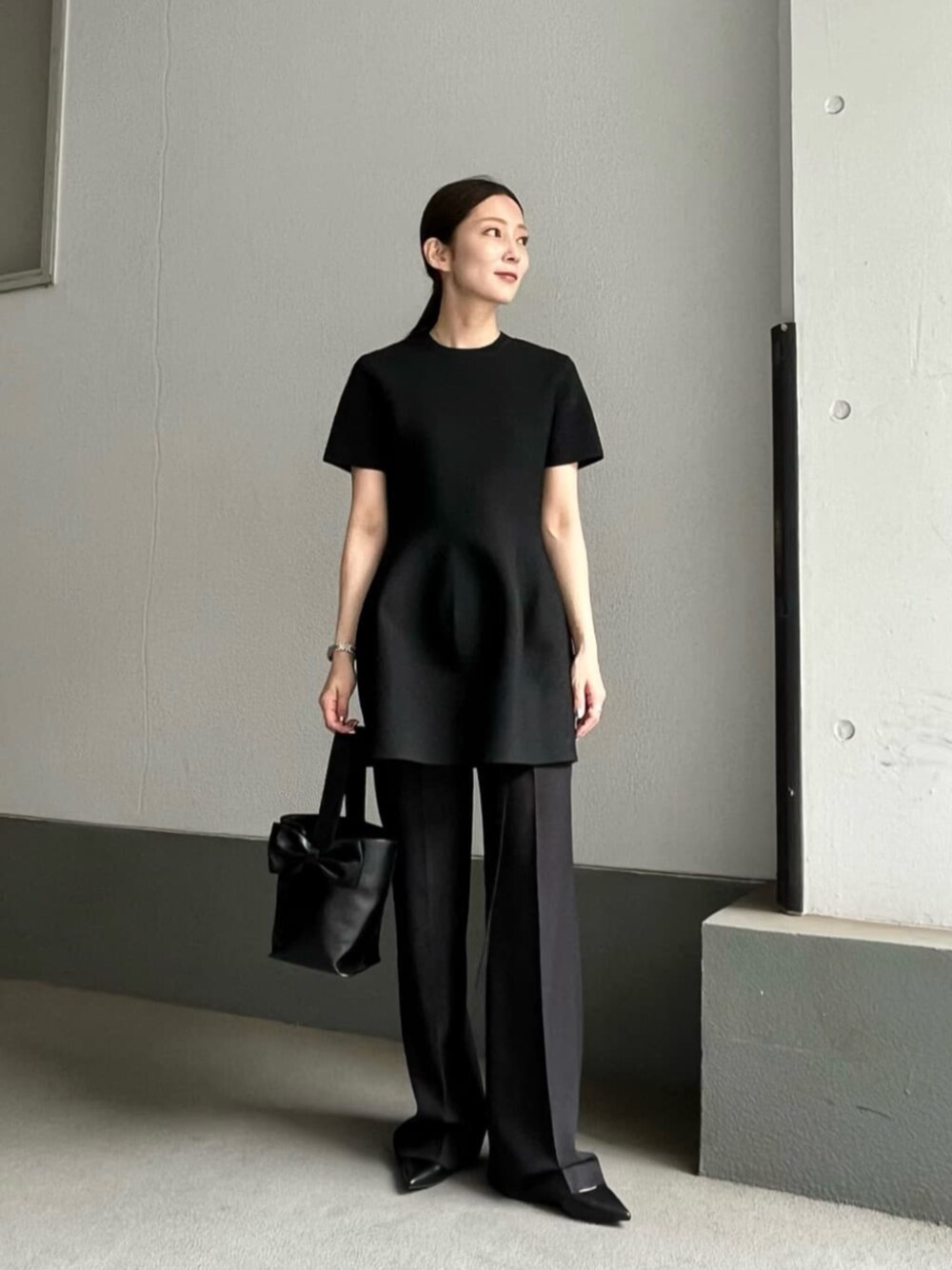 ブラック系のその他パンツ、ブラック系のハンドバッグ、ブラック系のニット/セーターを着用したレディースの夏コーディネートの1枚目の写真