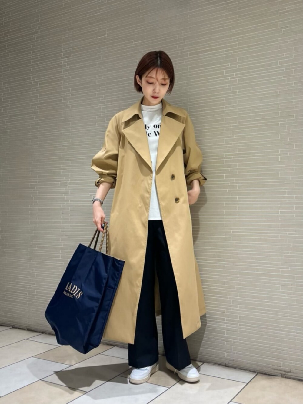 ブラック系のスラックス、ブルー系のトートバッグ、ホワイト系のTシャツ/カットソーを着用したレディースの春コーディネートの1枚目の写真