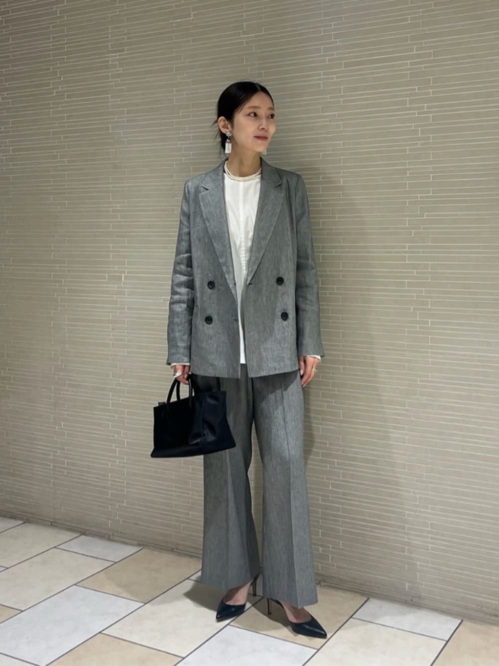 ブラック系のパンプス、ブラック系のトートバッグ、その他のテーラードジャケットを着用したレディースの春コーディネートの1枚目の写真